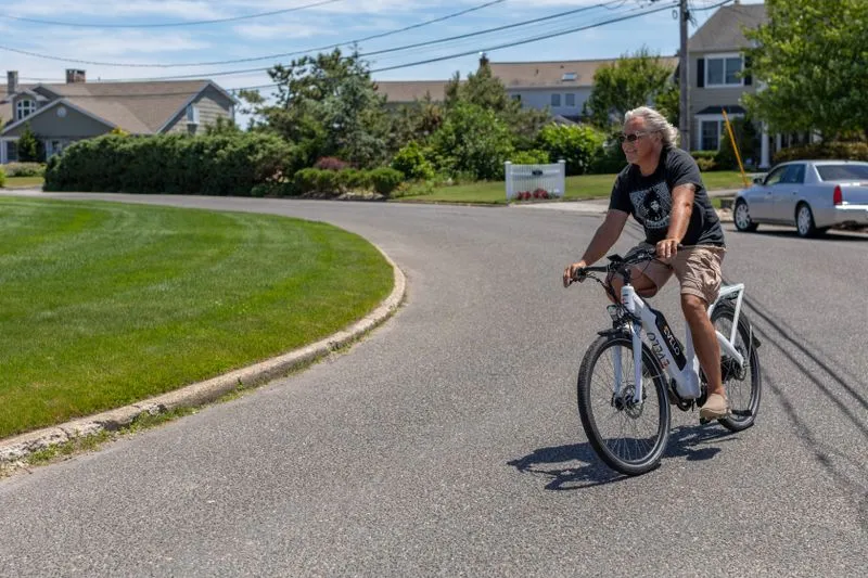 Man commuting through a suburban neighborhood on an electric bike