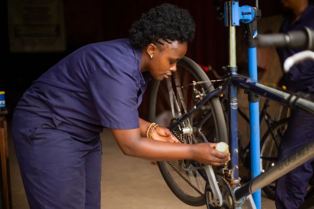 Mechanic servicing a bicycle on a workstand in a professional repair workshop
